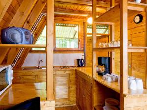 a kitchen in a wooden cabin with a microwave at Holiday Home Geesthof-8 by Interhome in Klint