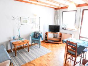 ein Wohnzimmer mit einem Tisch und einem TV in der Unterkunft Apartment Der Malerwinkel-3 by Interhome in Enkirch