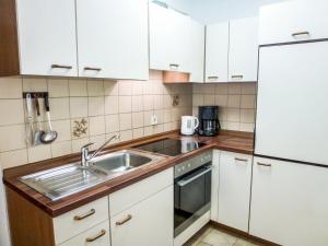 ヘーヘンシュヴァントにあるApartment Wohnung 12 - Frank by Interhomeのキッチン(白いキャビネット、ステンレス製のシンク付)