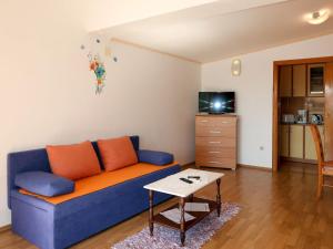 a living room with a blue couch and a table at Apartment Rudez-1 by Interhome in Gradac
