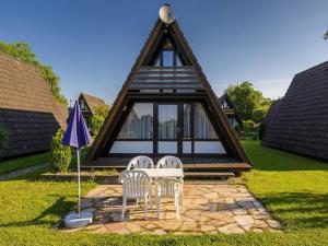 two chairs and a table and an umbrella in a yard at Holiday Home Ferienwohnpark Immenstaad-3 by Interhome in Immenstaad am Bodensee +20 photos