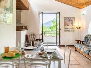 Reno Di LeggiunoにあるHoliday Home Casa nel Bosco by Interhomeのキッチン、リビングルーム(テーブル、椅子付)