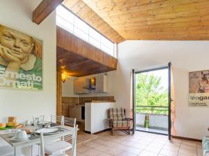 Holiday Home Casa nel Bosco by Interhome في Reno Di Leggiuno: مطبخ وغرفة طعام مع نافذة كبيرة