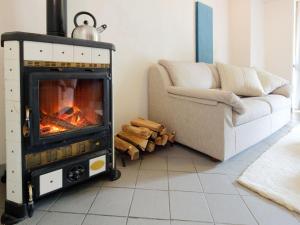a living room with a fireplace next to a couch at Apartment Ca' Marianna by Interhome in Roatto