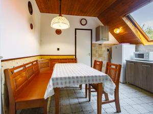 eine Küche mit einem Tisch und Stühlen sowie einem Kühlschrank in der Unterkunft Apartment Paulownia by Interhome in Balatonföldvár
