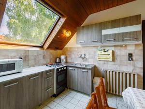 eine Küche mit Holzschränken und einem Fenster in der Unterkunft Apartment Paulownia by Interhome in Balatonföldvár