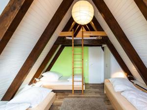 インメンシュタート・アム・ボーデンゼーにあるHoliday Home Ferienwohnpark Immenstaad-1 by Interhomeのベッド2台付きの部屋、屋根裏に梯子が備わる部屋