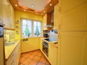 a yellow kitchen with christmas trees in the window at Holiday Home Lotsenhaus by Interhome in Groß Zicker