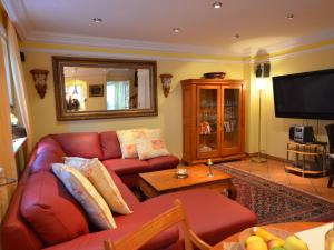 a living room with a red couch and a mirror at Holiday Home Lotsenhaus by Interhome in Groß Zicker