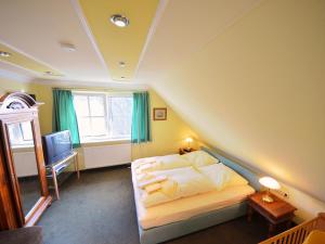 Schlafzimmer mit einem Bett, einem Fenster und einem TV in der Unterkunft Holiday Home Seeadler by Interhome in Groß Zicker