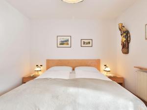 een slaapkamer met een groot bed met 2 nachtkastjes bij Apartment Tirol-1 by Interhome in Ortisei