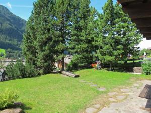 een tuin met twee grote bomen en gras bij Apartment Tirol-1 by Interhome in Ortisei