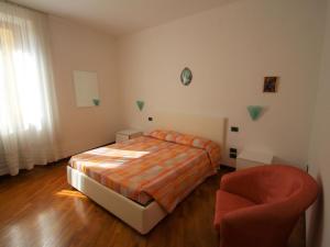 a bedroom with a bed and a chair at Apartment Formaga-1 by Interhome in Gargnano