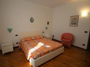 a bedroom with a bed and a chair in it at Apartment Formaga-1 by Interhome in Gargnano +14 photos