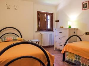 Fattoria SpedalettoにあるApartment Casanuova - Vecchia Cucina - LAI132 by Interhomeのベッドルーム1室(ベッド2台、ドレッサー、窓付)