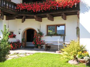 uma casa com flores vermelhas na frente em Apartment Tirol-2 by Interhome em Ortisei