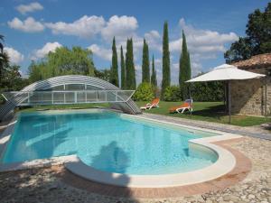 una piscina en un jardín con sombrilla en Holiday Home Casa Ingrid by Interhome, en San Venanzo