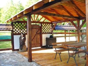 a wooden pavilion with a bench and a stove at Holiday Home Sianowska Huta by Interhome in Prokowo