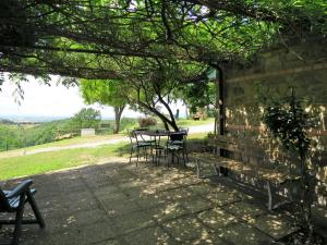d'une terrasse avec une table et des chaises sous un arbre. dans l'établissement Holiday Home Paradiso Selvaggio-2 by Interhome, à Paciano