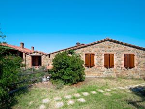 une vieille maison en pierre avec des portes en bois et une cour dans l'établissement Holiday Home Paradiso Selvaggio-2 by Interhome, à Paciano