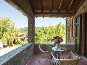 a patio with chairs and a table with a vase of flowers at Apartment Casa Domenico n- 1 by Interhome in Montefiascone