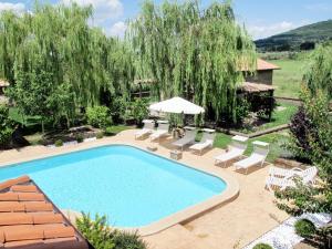 a swimming pool in a yard with chairs and an umbrella at Apartment Casa Alessandro n-5 by Interhome in Montefiascone
