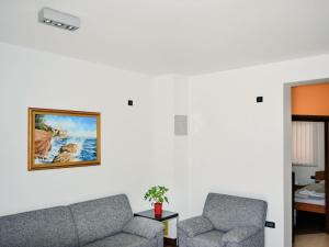 a living room with two chairs and a picture on the wall at Apartment Jadranka-1 by Interhome in Rab