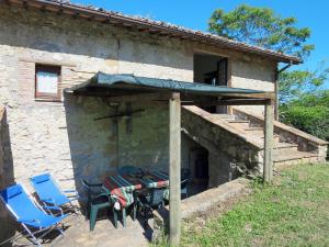 una mesa y sillas frente a una casa de piedra en Apartment Sociano-2 by Interhome, en Vaiano