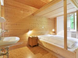ein Schlafzimmer mit einem großen Bett und einem Waschbecken in der Unterkunft Apartment Puntea by Interhome in St. Ulrich in Gröden