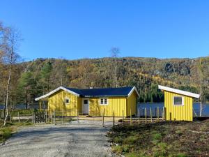 um edifício amarelo ao lado de uma massa de água em Holiday Home Oddbu - SOW103 by Interhome em Åseral