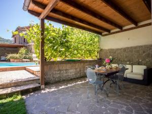 een patio met een tafel en stoelen en een zwembad bij Apartment Casa Riccardo n- 3 by Interhome in Montefiascone
