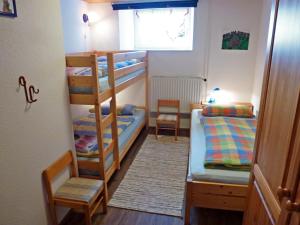 a room with two bunk beds and two chairs at Apartment Schuler by Interhome in Unterkirnach