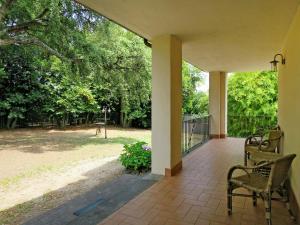 eine Veranda mit 2 Stühlen, einem Zaun und Bäumen in der Unterkunft Apartment Casale Zuccari-2 by Interhome in Carbognano