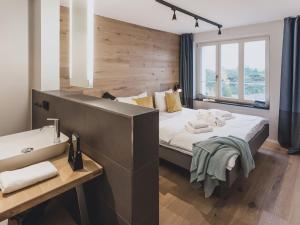 a bedroom with a large bed and a sink at Apartment Mariandl am Meer-2 by Interhome in Binz
