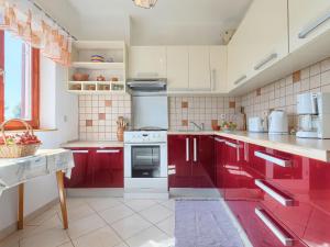 uma cozinha com armários vermelhos e um fogão branco em Holiday Home Ana Lucija - RCA508 by Interhome em Pula