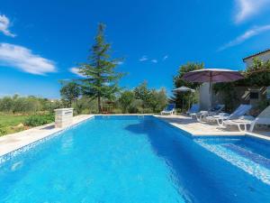 uma piscina com cadeiras e um guarda-sol em Holiday Home Ana Lucija - RCA508 by Interhome em Pula