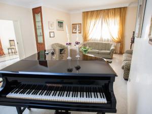 czarny fortepian w salonie z kanapą w obiekcie Villa Incoronata by Interhome w mieście Nardò