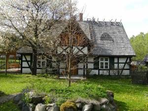 an old house with a tree in front of it at Holiday Home Sianowska Huta by Interhome in Sianowska Huta