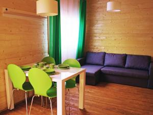ミエレンコにあるHoliday Home Onyx-2 by Interhomeのテーブル、緑の椅子、ソファが備わる客室です。