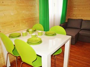 una mesa blanca con sillas verdes y un sofá en Holiday Home Onyx-1 by Interhome, en Mielenko