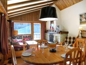 een eetkamer met een tafel en stoelen en een kamer met een open haard bij Apartment Parc B 431 by Interhome in Champex