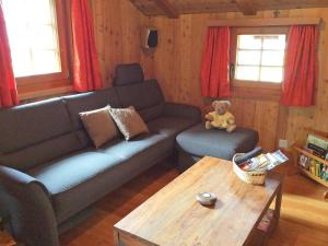 a living room with a couch and a teddy bear at Chalet Bildji by Interhome in Staldenried