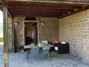 a patio with a table and chairs in a brick wall at Apartment Casa Alessandro n- 6 by Interhome in Montefiascone