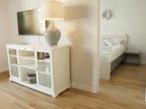 a lamp on a white cabinet in a room with a bed at Apartment Na Wczasowej by Interhome in Ustka