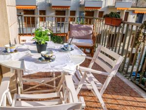 - Balcón con mesa blanca y sillas en Apartment Casa Nicoló by Interhome, en Poggio