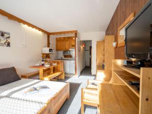 ティーニュにあるStudio Le Slalom - Val Claret-3 by Interhomeの小さなリビングルーム(ソファ付)、キッチンが備わります。