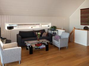 ein Wohnzimmer mit einem Sofa, 2 Stühlen und einem Tisch in der Unterkunft Holiday Home Jektastøo - FJH660 by Interhome in Nordhuglo