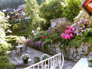 a garden with tables and chairs and flowers at Apartment Maier-1 by Interhome in Triberg