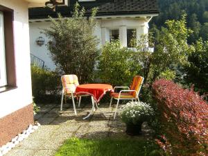 3 Stühle und ein Tisch vor einem Haus in der Unterkunft Apartment Maier-1 by Interhome in Triberg