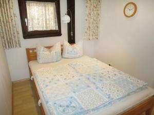 een bed met een blauwe en witte quilt bij Apartment Fliederweg by Interhome in Siegsdorf